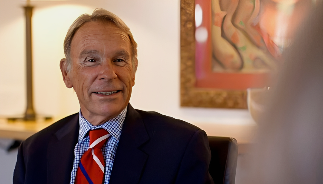 Smiling man in suit with colorful tie.