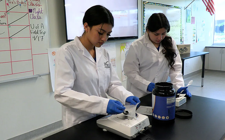 Students conducting a science experiment in lab.